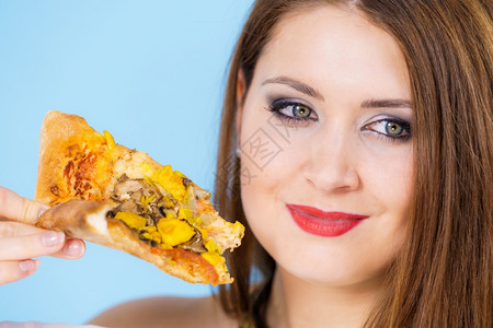 青春女子在蓝色上吃热新鲜披萨片美味快餐人们意大利菜概念女在吃热披萨片图片