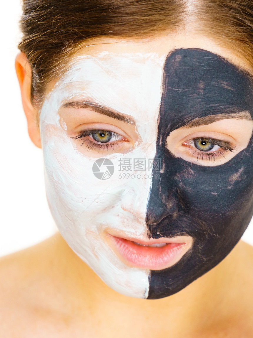 白泥涂在干净的皮肤上女孩照顾油色的皮肤美容程序皮肤护理黑脸涂在白色的上图片