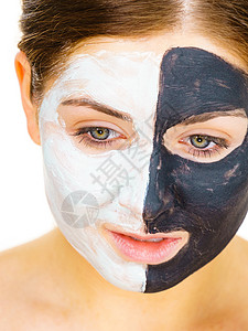 白泥涂在干净的皮肤上女孩照顾油色的皮肤美容程序皮肤护理黑脸涂在白色的上背景