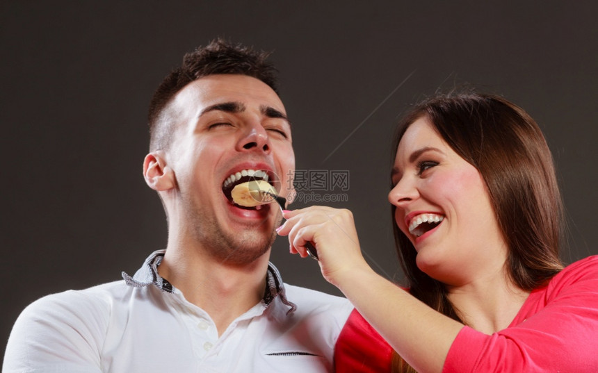 微笑的妻子用香蕉喂快乐的丈夫男人和女吃水果健康营养饮食和苗条概念微笑的妻子用香蕉喂快乐的丈夫图片