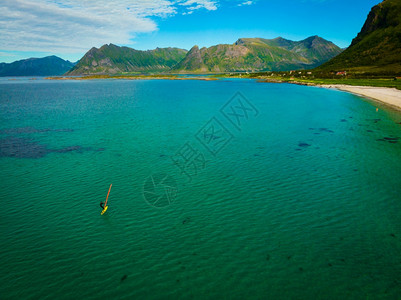 挪威Lofoten公司挪威光水海滩上冲浪者的空中观察背景图片