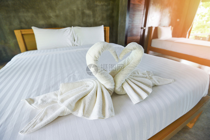 床铺内装饰卧室的白色干净浴巾旅馆客房床上的白色毛巾图片