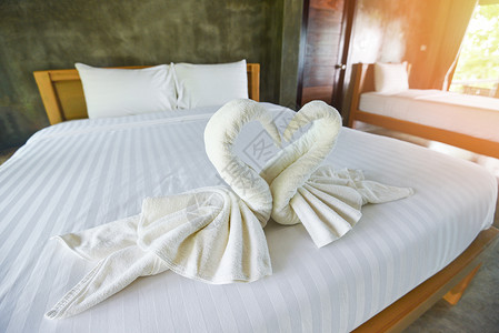 床铺内装饰卧室的白色干净浴巾旅馆客房床上的白色毛巾图片