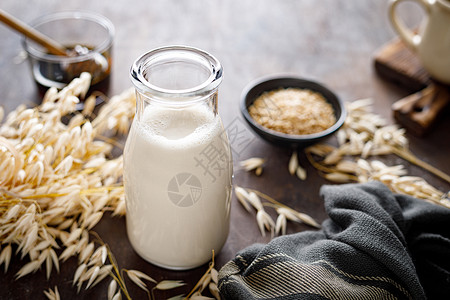 替代食物以玻璃瓶和烹饪用原料装的维加燕麦健康的素食非乳品饮料或替代牛奶背景