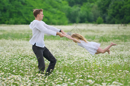 快乐的父亲和女儿在大卡莫米尔山草地玩耍情感爱和照顾的场景背景