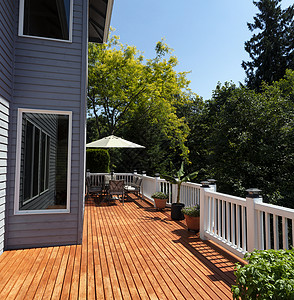 与季节花园一起在美丽的夏日家门口的木甲板庭院图片