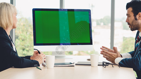 会议室的商人办公桌上有绿色屏幕染体钥匙电视或计算机高清图片