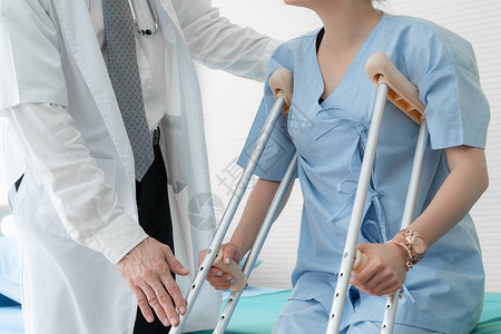 医生照顾院的拐杖病人理疗师和腿部受伤康复概念图片