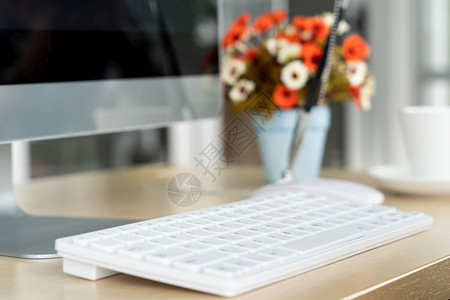 在小型现代办公室或家用的桌上关闭键盘面电脑Trendy工作场所内部图片