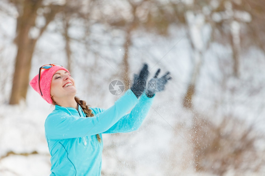 在冬季公园放松的年轻女健康自然的时装身概念女孩在周围吹雪图片