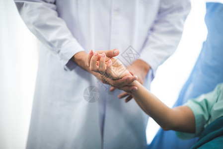 近距离医生在务室内拉着病人的手代表舒适希望温暖和封闭图片