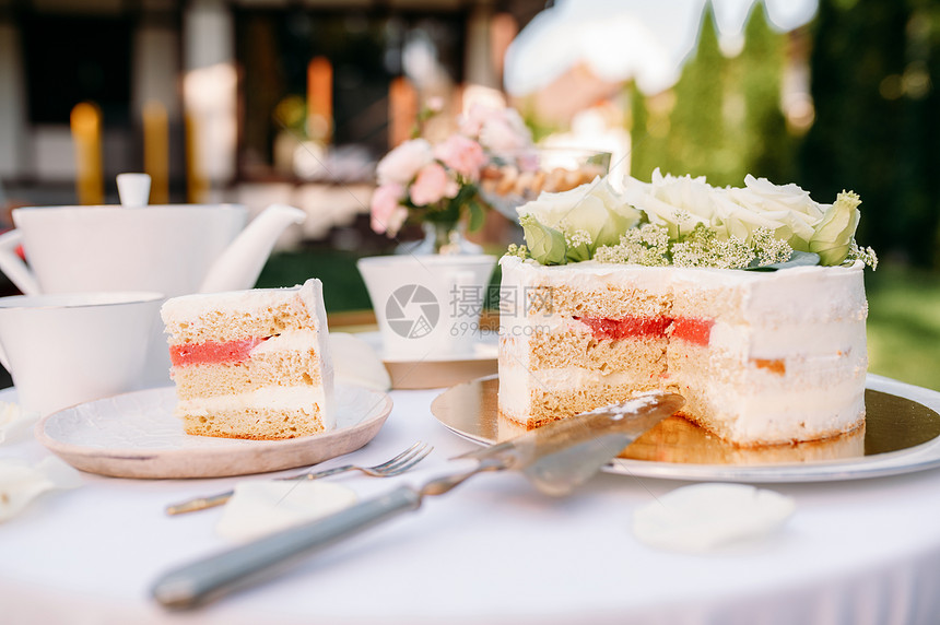 餐桌设置茶会新鲜蛋糕的闭幕观白桌布上的奢华银器户外的餐桌具夏季草地的婚礼庆祝活动蛋糕的闭幕观图片