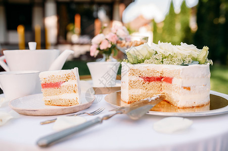 餐桌设置茶会新鲜蛋糕的闭幕观白桌布上的奢华银器户外的餐桌具夏季草地的婚礼庆祝活动蛋糕的闭幕观背景图片