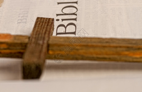 旧的黄页开放圣经和一个简单的木制关闭图片