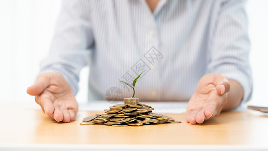 手发芽商人的手把硬币放进植物发源的成长为营利通过储蓄计划和投资显示金融增长背景