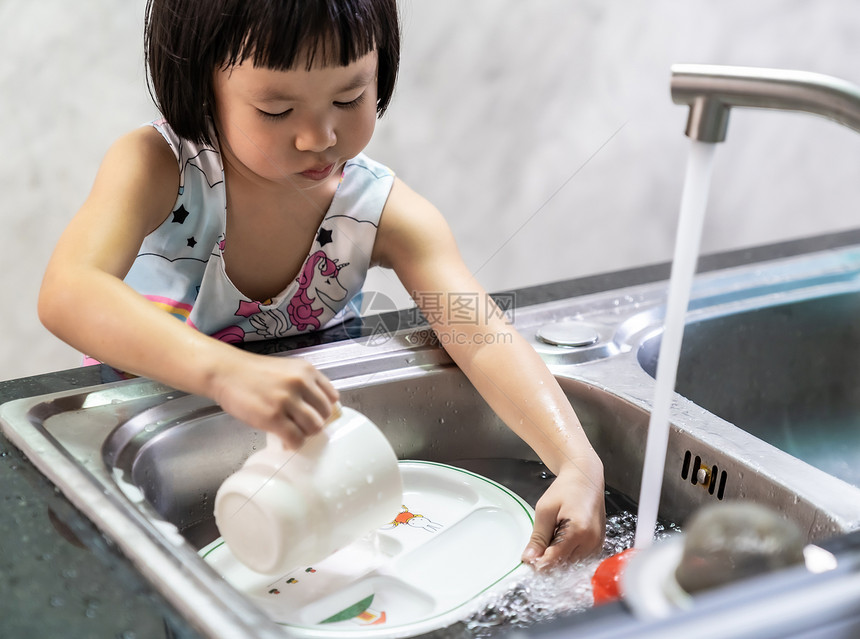 亚洲女孩独自洗盘子和餐具儿童家务使发挥行政职能家庭工作是为了孩子的生活方式和家庭概念图片