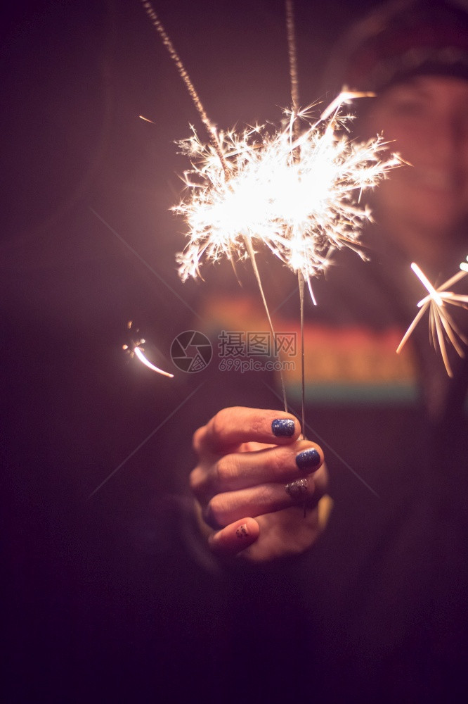 微笑的女孩手握着火花新的一年户外图片