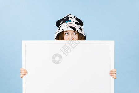 穿着有趣的夜衣少女睡卡通风格用空白的横幅板遮盖她的脸广告复制空间图片
