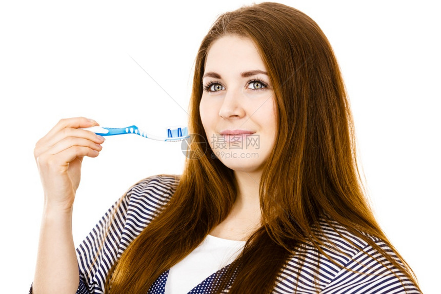 穿着睡衣的妇女拿有糊的牙刷微笑着正女孩准备打扫牙齿口腔卫生孤立在白色上女人拿着有糊的牙刷图片