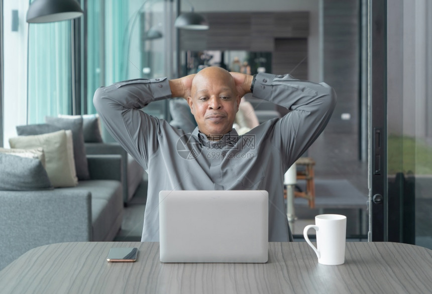 年长的黑人美国商在家工作的非洲人想到电脑笔记本电脑的问题和在冠状大流行概念的检疫中患有抑郁症图片