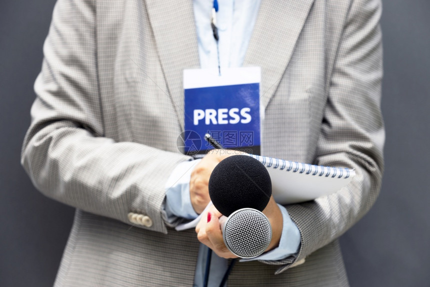 参加新闻发布会或媒体活动写笔记持有麦克风的女记者图片