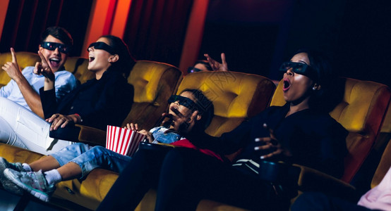 一群人在电影院看三维眼镜的电影有兴趣观看屏幕奋和吃爆米花图片