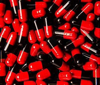 胶囊中许多红色黑药丸的背景图片