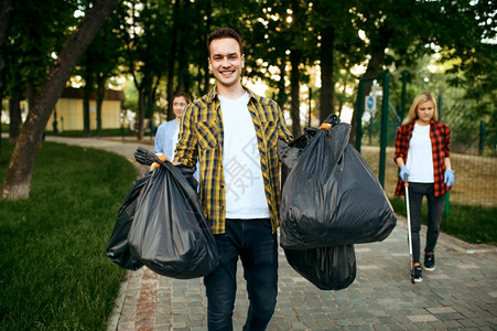 自愿者在公园里持有完整的塑料垃圾袋志愿工作男清洁森林生态恢复活方式垃圾收集和回生态护理环境清洁背景
