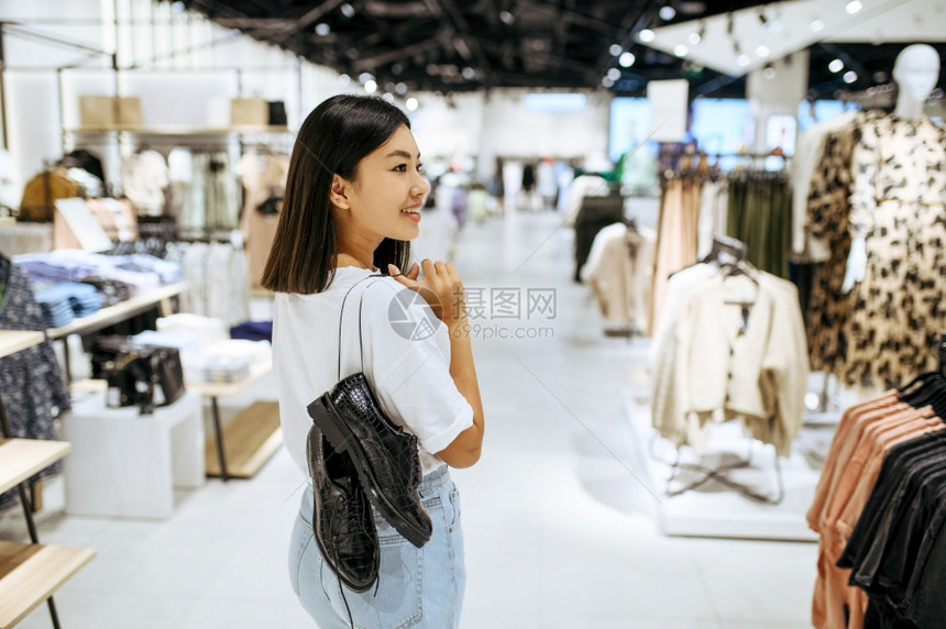 美貌女在服装店有鞋子女在时装店商购物偷看靴子的购物女在服装店有鞋子图片