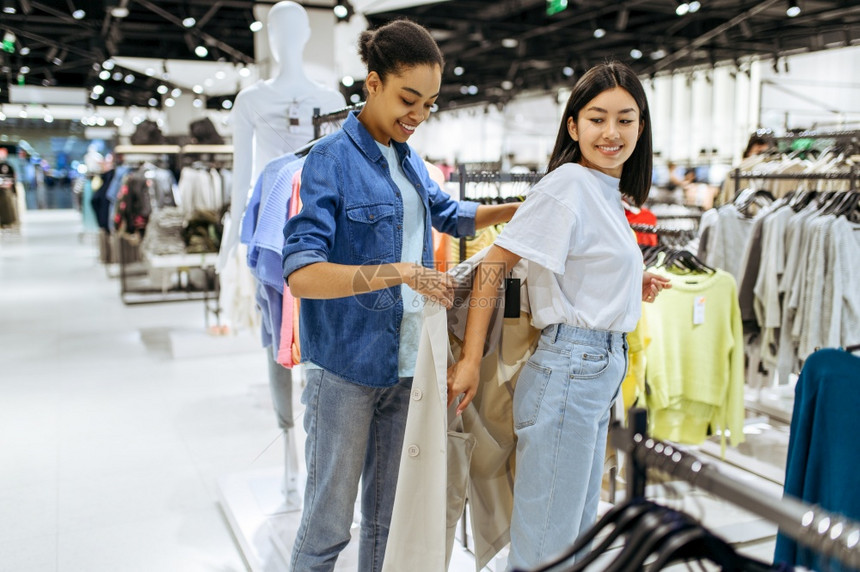 两个女孩在服装店试穿大衣两个女孩在服装店试穿大衣图片