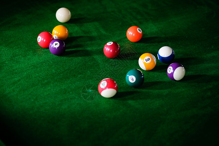 Man手和Cue臂在玩Snooker游戏或准备在绿色球桌上绿色盘上有多彩的Snooker球背景图片