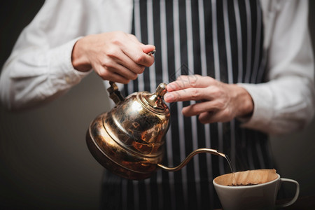 咖啡店从茶壶里倒热水在咖啡粉上提取店里新鲜酿成的咖啡图片