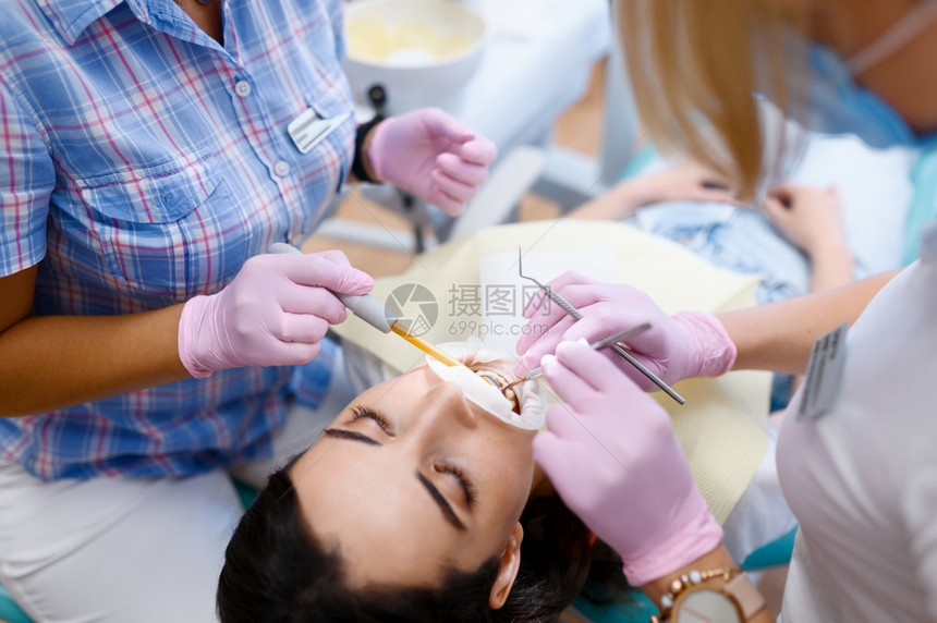 女牙医和助理在诊所口腔科为病人工作穿制服的医生务工作者药和保健专业牙齿护理科女医和助理为病人工作图片