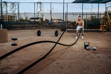 年轻运动员在沙地上用格斗绳健身锻炼
图片