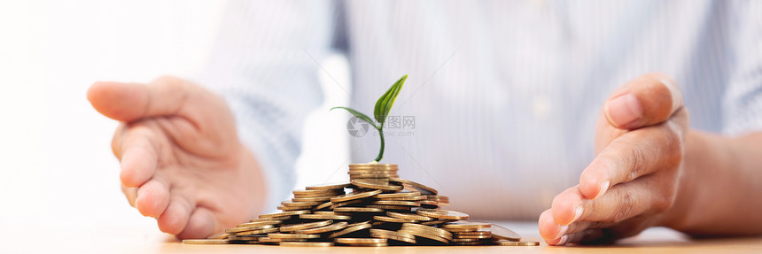 商人的手把硬币放进植物发源的成长为营利通过储蓄计划和投资显示金融增长图片