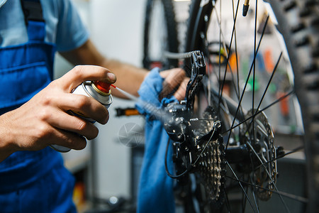 修理车间的自行人清洗明星磁带特机修理周期有制服问题的机械师专业自行车修理服务车间的自行人清洗磁带背景图片