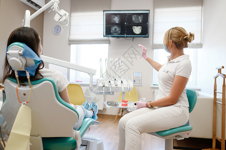 女牙医看齿X光的病人口腔诊所穿制服的医生务工作者口腔医生药和保健专业牙科口腔保健和卫生牙医女看齿的病人X光背景图片