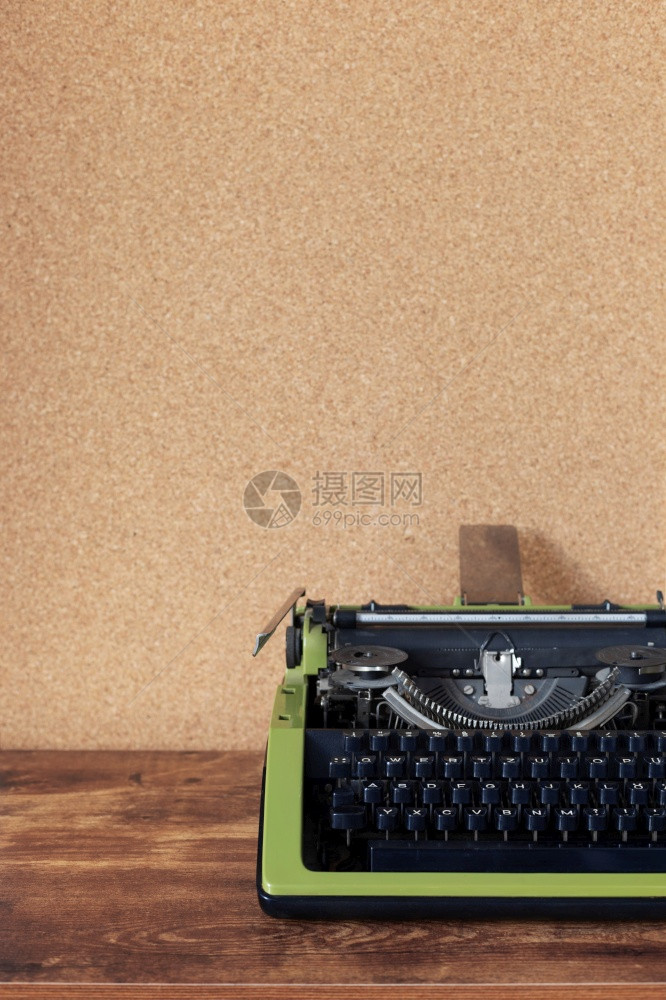 壁背景表面在软木板附近的桌旁老式打字机图片