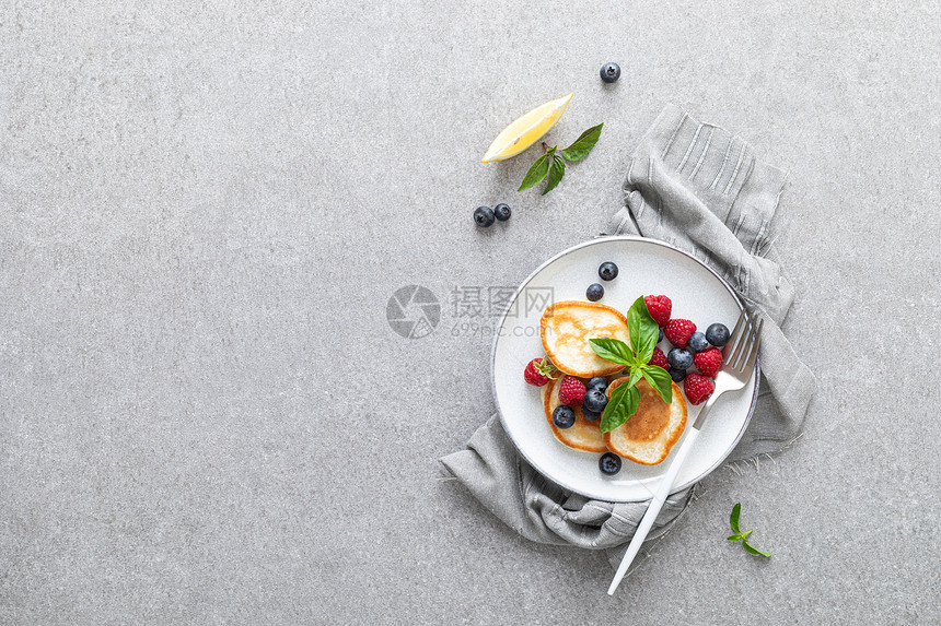 带新鲜蓝莓和草的煎饼用于健康素食早餐图片
