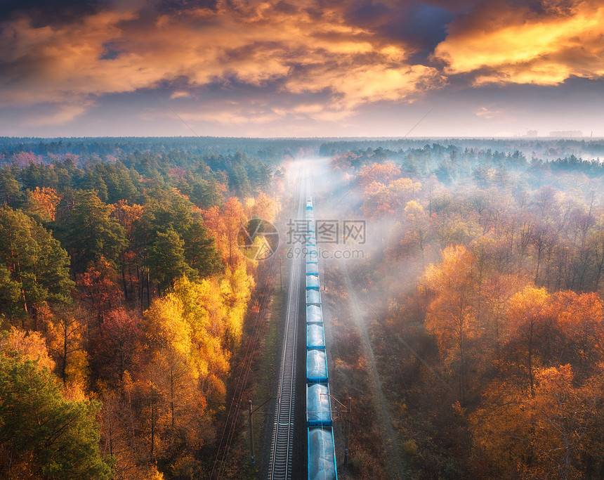 秋天日落时雾中美丽的森林货运列车的空景象铁路雾树小径和云彩多的天空风景图片