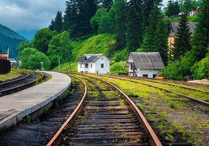 日落时山村的火车站和小白屋夏季高覆溢日的农村铁路平台绿树草地云天建筑的工业景观背景图片