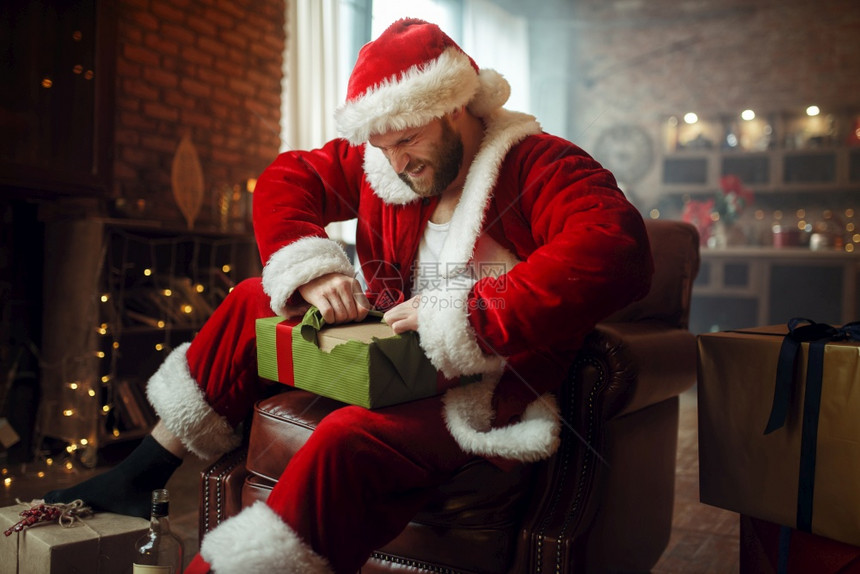 坏醉的圣誕老人在诞树下开礼物流的派对幽默不健康的生活方式在节日服装新年和酗酒中留胡子的男新年和酗酒图片