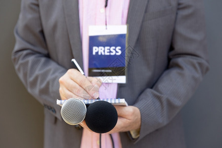 记者招待会或媒体活动记者写笔拿着麦克风广播新闻概念图片