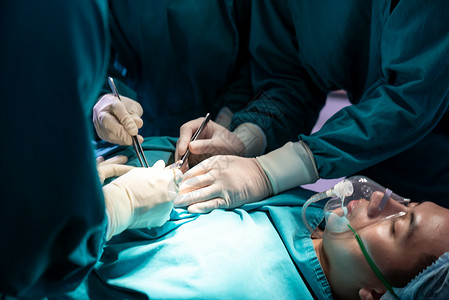 外科医生和从事手术的护士与室的小组一起接受治疗医外科手术概念图片