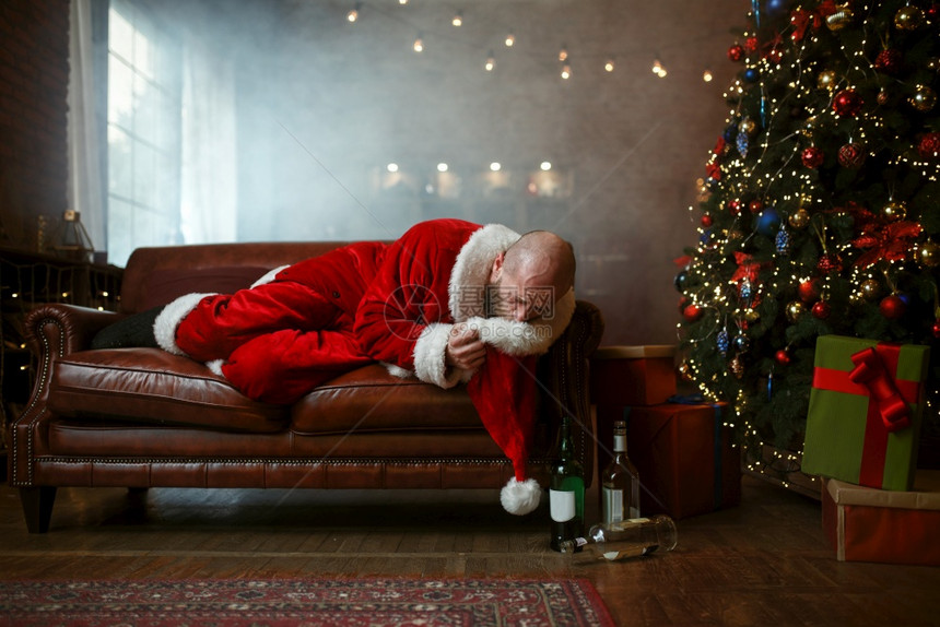 臭醉如泥的圣诞老人在帽子里呕吐,讨厌的派对后宿醉、幽默不健康的生活方式、在节日服装新年和酗酒中留胡子的男、在新年和酗酒中胡须、在图片