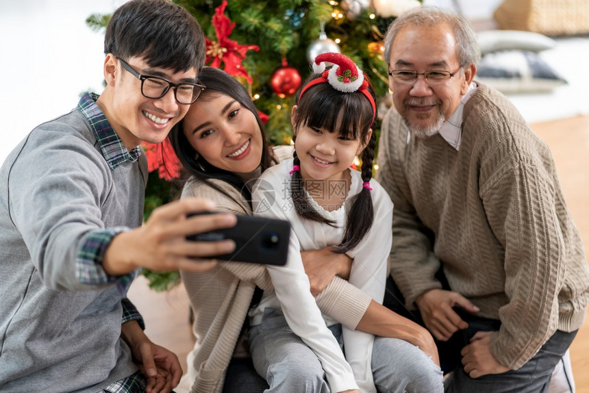 多代的亚裔家庭妈女儿和祖父在装饰圣诞品后图片
