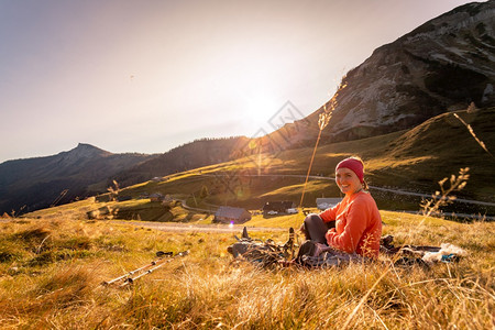 穿运动服的妇女正在享受山区的日落坐在地上享受风景图片