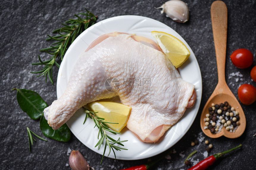 鸡腿在白色盘子上的原生鸡腿用来在木制食品桌上煮白菜图片