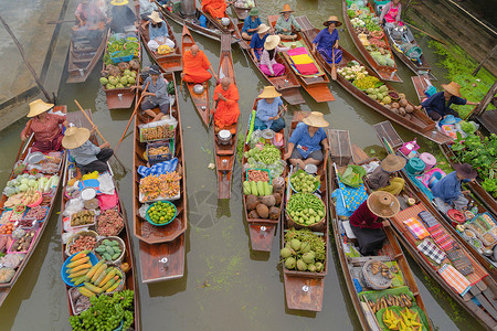 船上的人DamonoenSaduakFloating市场或Amphawa当地人出售水果和传统食品在泰国拉恰布里区运河的船上出售亚洲著名的背景
