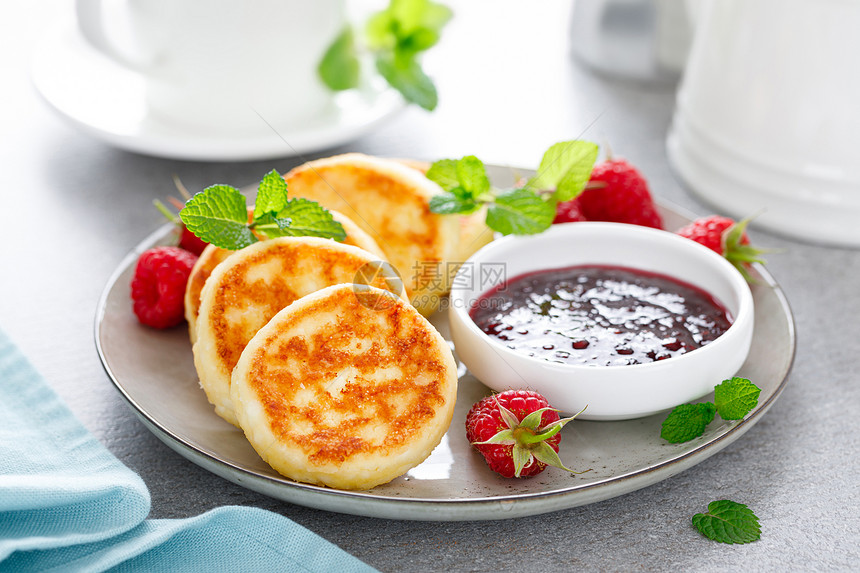 奶油芝士煎饼甜卷和浆果酱新鲜草莓在早餐桌上图片